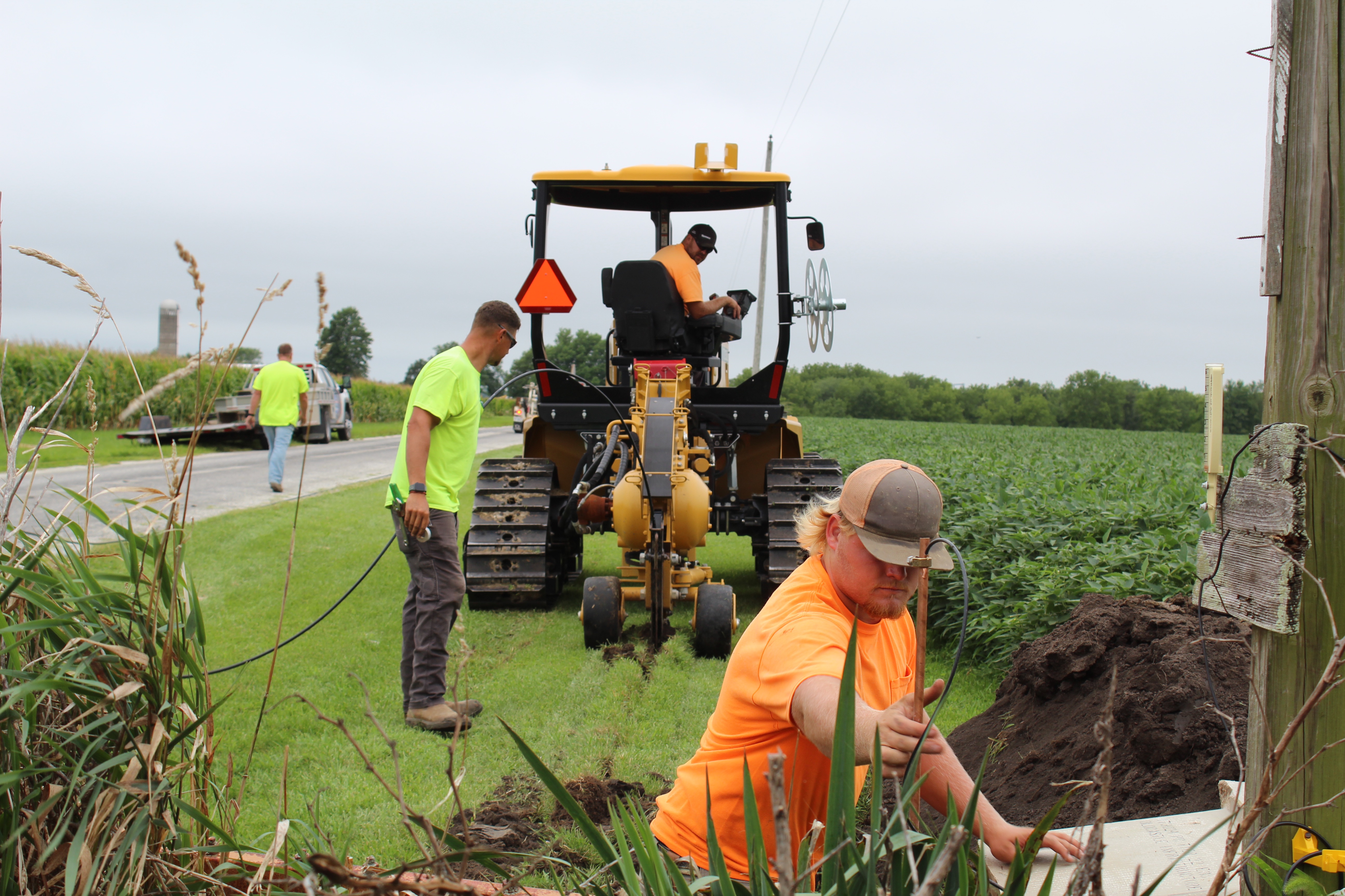 A fiber crew installing service along a rural road.
